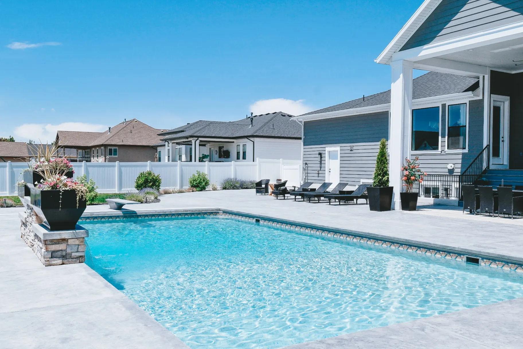 Farmington Utah Vinyl Pool & Stamped Concrete Patio - Barr Pool Builders Custom vinyl inground swimming pool with stamped concrete patio, diving board and outdoor dining in Farmington, Utah by Barr Pool Builders