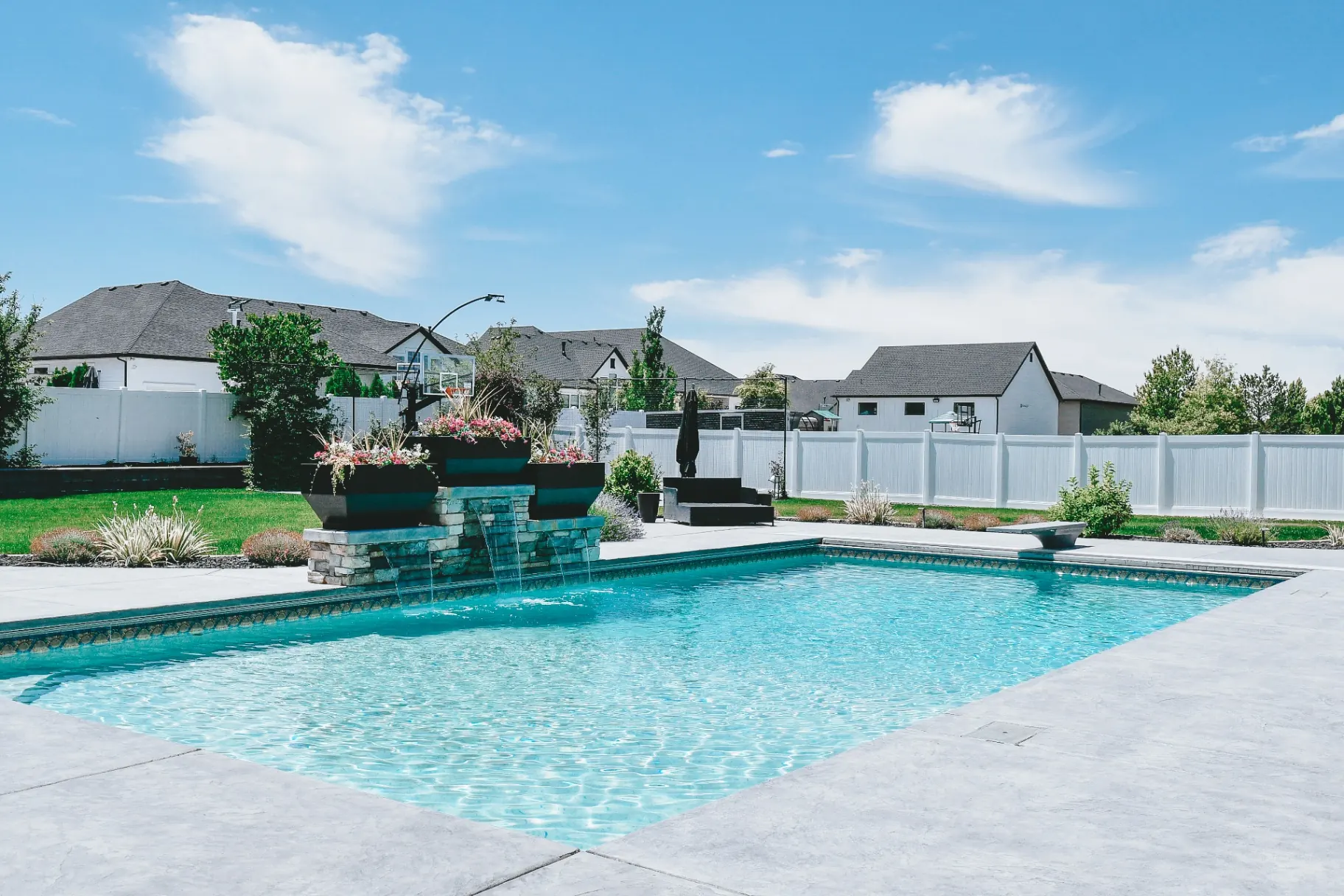 Syracuse Utah Backyard Pool Oasis with Stone Fountain - Barr Pool Builders Custom backyard swimming pool oasis with cascading stone fountain water feature in Syracuse, Utah by Barr Pool Builders